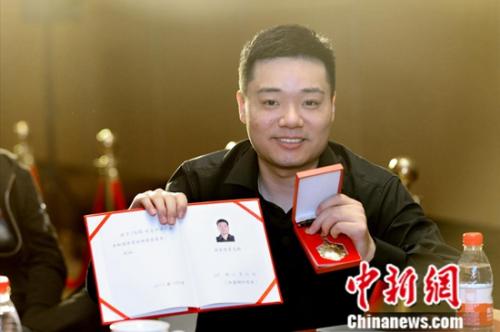 丁俊晖获得国家体育运动荣誉奖章和证书。组委会供图 点击进入下一页